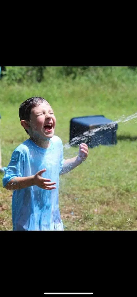 A child enjoys an activity outside on the grass
